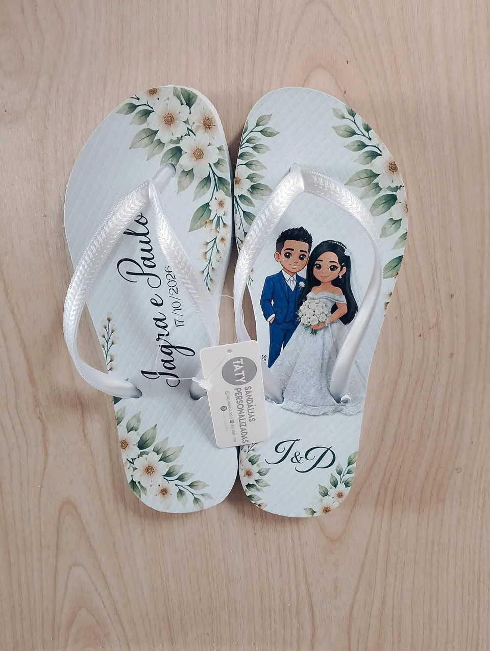 Chinelos de casamento com ilustração do casal e flores claras. Foto de pedido real da Taty.